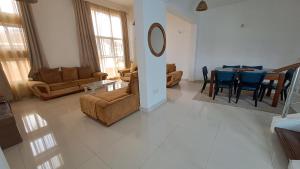 a living room with couches and a dining room at Ary Homestay Nyali- Town Home Behind Citymall in Mombasa