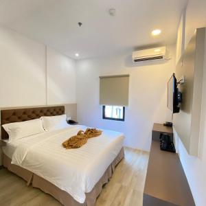 una camera da letto con un letto bianco con una coperta marrone di BATAM 1 HOTEL a Nagoya