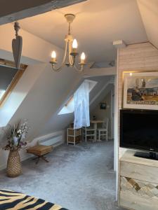 una sala de estar con un ático con una gran TV en La Marine Louannec, en Louannec