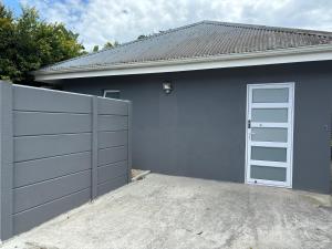 a garage with a white door and a driveway at Prospect Road Cottage in Walmer