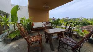 a table and chairs on a balcony with a bed at Ary Homestay Nyali- Town Home Behind Citymall in Mombasa