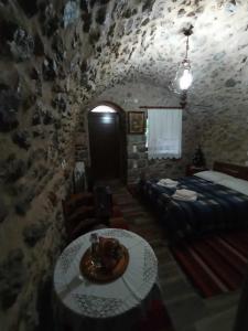 una habitación con una mesa y una cama y una habitación con una pared en Ο ΘΟΛΟΣ en Stemnitsa