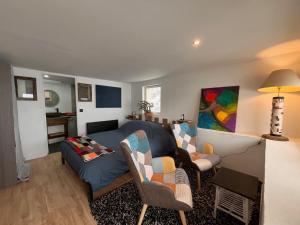 a living room with a couch and chairs at LE MOULIN DE NAVETTE -La Roue in Aigueblanche