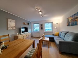 a living room with a blue couch and a table at Ferien und Gästewohnung Hettstedt in Hettstedt