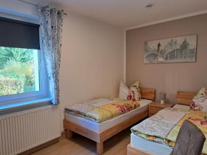 a bedroom with two twin beds and a window at Ferien und Gästewohnung Hettstedt in Hettstedt