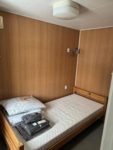 ein kleines Schlafzimmer mit einem Bett in einem Zimmer in der Unterkunft Dvaro namai 