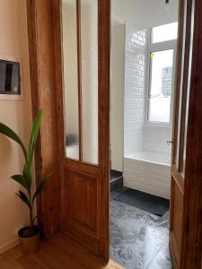 een badkamer met een houten deur en een bad bij Boho Apartments - 2 Bedrooms in Antwerpen