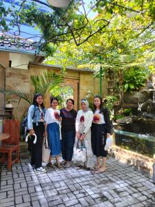 a group of women standing in front of a garden at Pujihouse One in Legian