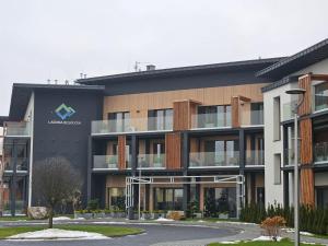 a building with a sign on the side of it at Apartament Laguna Beskidów - Zarzecze in Zarzecze