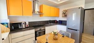 a kitchen with a wooden table and a refrigerator at Istrian Lux Residence in Koper