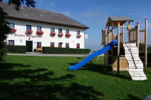 a playground with a slide in front of a building at Brettmaisserhof in Ternberg