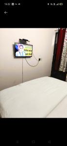 TV colgada en una pared sobre una cama en HOTEL CASTLE HOME STAY en Jaipur