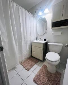 y baño con aseo, lavabo y espejo. en Cute 3 Bedroom Home in Beautiful Brown Deer en Brown Deer