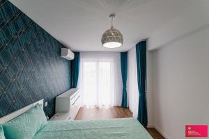 a bedroom with a green bed and a window at The Cozy One in Târgu-Mureş