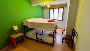2 stapelbedden in een kamer met groene muren bij Vivac Jaca in Jaca