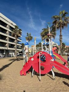 un parque de avionetas rojas en una playa con palmeras en Sol de mar, La Mata (Hiszpania), en La Mata