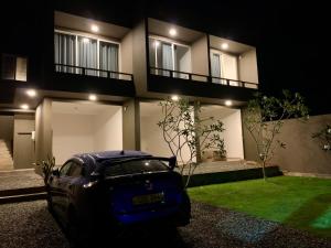 安伯朗戈德的住宿－Villa beachcomber，夜间停在房子前面的汽车