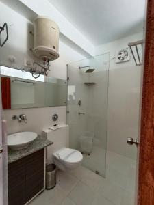 een badkamer met een toilet, een wastafel en een douche bij Gezellig Inn - Hotel Oasis in Kulu