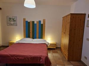 ロッカラーゾにあるResidenze Macerelliのベッドルーム1室(ベッド1台付)、木製キャビネットが備わります。
