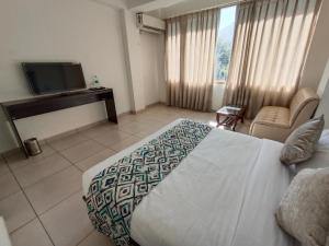 Habitación de hotel con cama y TV en Gezellig Inn - Hotel Oasis, en Kulu