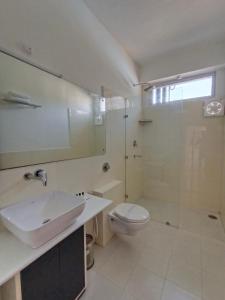 a bathroom with a sink and a toilet and a shower at Gezellig Inn - Hotel Oasis in Kulu
