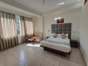 a bedroom with a large bed and a chair at Gezellig Inn - Hotel Oasis in Kulu