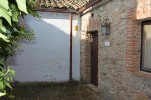 een witte garage met een deur en een bakstenen gebouw bij Los Naranjos in Trujillo
