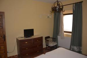 een slaapkamer met een bed en een bureau met een tv. bij Los Naranjos in Trujillo