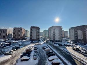 ein schneebedeckter Parkplatz in einer Stadt in der Unterkunft Apartman Sunny, Istocno Sarajevo - Lukavica in Sarajevo