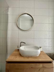 ein Badezimmer mit einem weißen Waschbecken und einem Spiegel in der Unterkunft Apartman Sunny, Istocno Sarajevo - Lukavica in Sarajevo