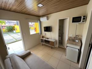 uma sala de estar com um sofá e um lavatório em Apartamento em Itaparica em Bôca do Rio