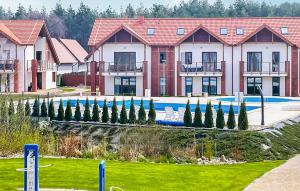 a row of houses with a swimming pool and trees at Amazing Apartment In Zarnowska With Kitchen in Żarnowska