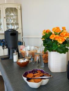 een aanrecht met een kom koekjes en een vaas met bloemen bij Hotel Charlotte / Stella in Uppsala