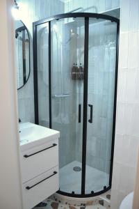y baño con ducha y lavabo blanco. en Studio 88, en Courbevoie