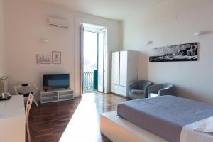 a white bedroom with a bed and a television at Palazzo Mirelli in Naples