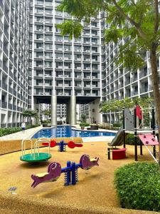 une aire de jeux en face d'un grand bâtiment dans l'établissement Stylist Luxe Condo near Mall of Asia - Shore 3, à Manille