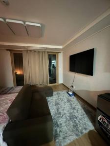 a living room with a couch and a flat screen tv at (NEW) Luxury Condo in Clark 