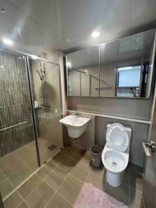 a bathroom with a toilet and a sink and a shower at (NEW) Luxury Condo in Clark 