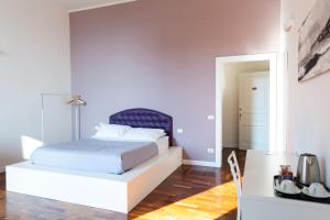 a white bedroom with a bed and a mirror at B&B Palazzo Mirelli in Naples