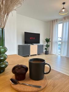 a cup of coffee and a muffin on a table at AMAO-Grey I 86qm I KingSizeBetten I Netflix I Balkon I Parkplatz I EuropaPark in Rheinhausen