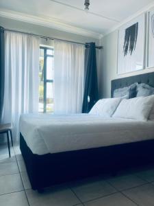 una camera con un grande letto e una finestra di Lethabo Eco_Estate a Boksburg