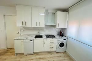 uma cozinha com armários brancos e uma máquina de lavar roupa em Nórdico -Apartamentos Birdie- em Albacete