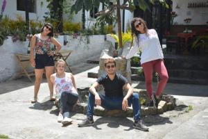 a group of people standing around a man and woman at El Yarumo Hostel in Bogotá