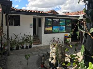 uma casa com janelas e plantas em frente em El Yarumo Hostel em Bogotá