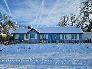 a blue house with snow in front of it at Charmantes Eifel Ferienhaus an der Schavener Heide in Mechernich