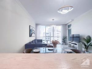 uma sala de estar com um sofá e uma mesa em Luxurious 1B Seaview Apartment in JBR em Dubai