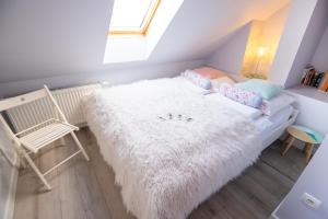 ein Zimmer mit einem weißen Sofa mit Kissen und einem Fenster in der Unterkunft Apartamenty Centrum - Moonlight in Oppeln