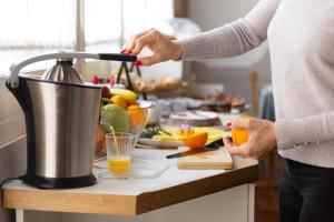 a woman preparing orange juice in a kitchen at B&B Palazzo Mirelli in Naples