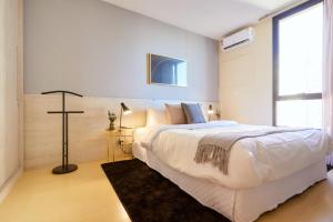 a white bedroom with a large bed and a window at Charlie Top Apart Leblon in Rio de Janeiro