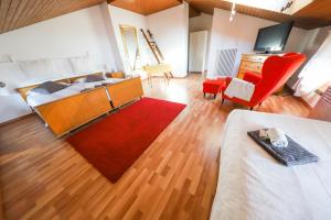 a living room with a bed and a red rug at Casa Zen in Balerna